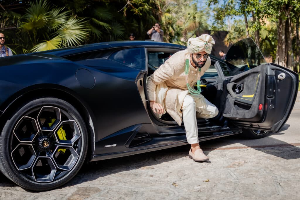 Groom stepping out of a McLaren on his wedding day