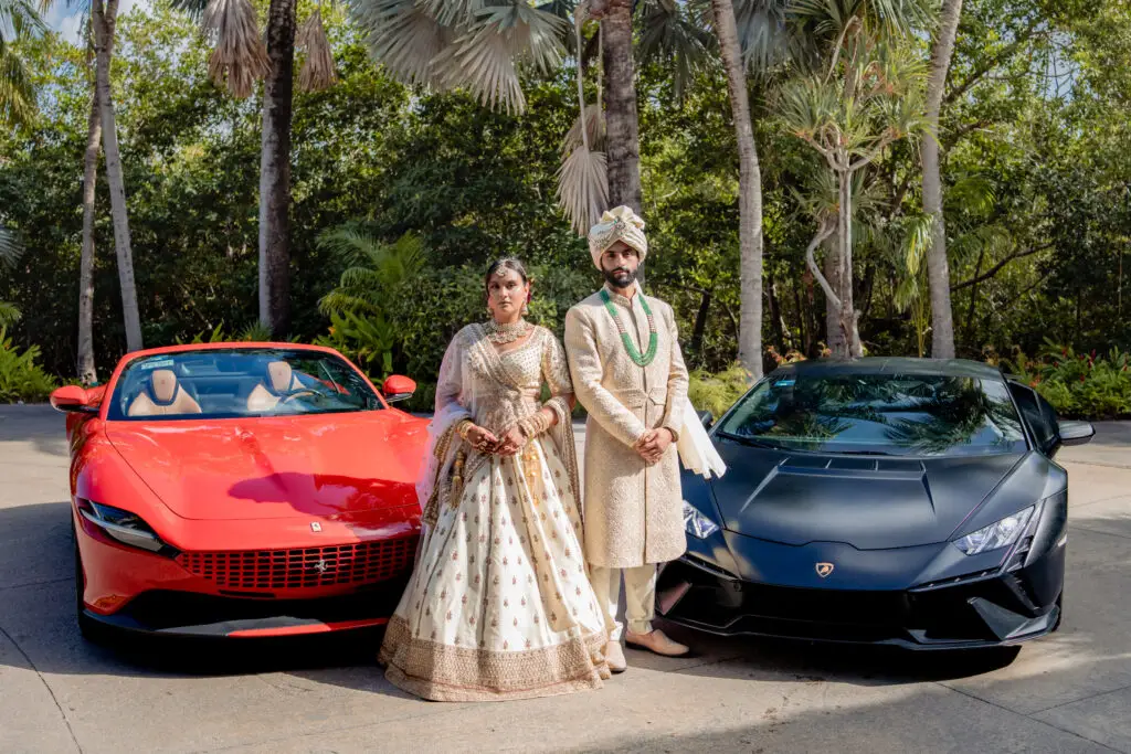 Wedding couple between a Ferrari and McLaren in a tropical setting
